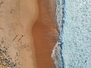 Aerial view from a couple walking in a sandy beach. Drone photo