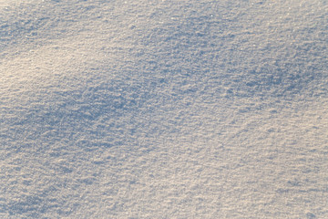 Background of white snow sparkling in the sun. Shallow depth of field