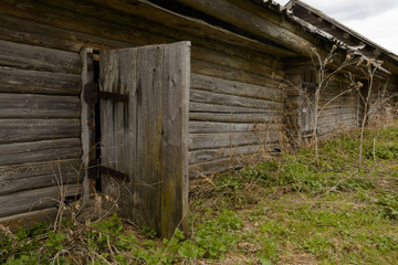 old wooden log cabin with an open door