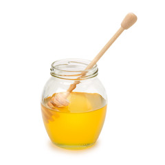 Bee honey in glass jar and wooden spoon isolated on white