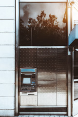 Frontal vertical view street cash machine ATM with a blank screen and a metal pattern around; an outdoor automated teller machine