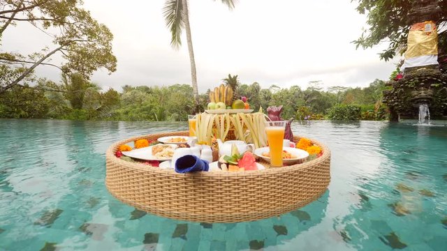 Floating Tropical Breakfast at Swimming Pool. 4K. Bali, Indonesia.