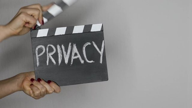 Privacy concept. Female hands holding movie clapper.