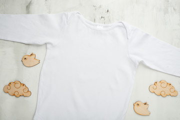 Layout Flat Lay white baby bodysuit shirt, on a white background with children's wooden toys. Mock...