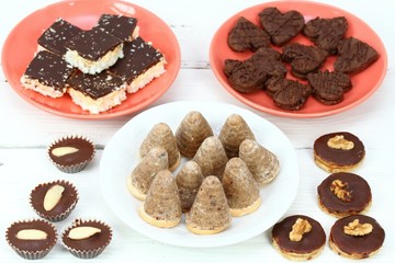 Christmas candies on the red plate / Xmas confectionery on the white wooden board