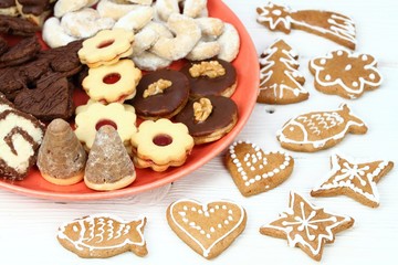 Fototapeta na wymiar Christmas candies on the red plate / Xmas confectionery on the white wooden board