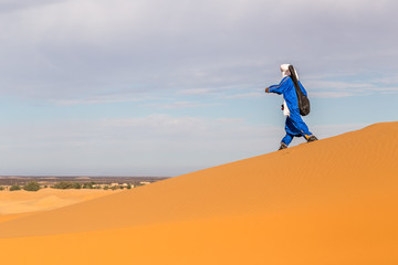 Berber man walking in Erg Chebbi desert near Merzouga, Sahara desert
