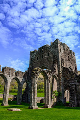 Landmarks of Wales travel concept. View of ancient ruins of the castle/church in Brecon Beacons National Park, United Kingdom. Popular tourist attraction (Llanthony Priory,Hay-on-Wye, Black Mountains)