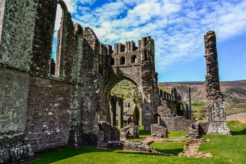 Fototapeta na wymiar Landmarks of Wales travel concept. View of ancient ruins of the castle/church in Brecon Beacons National Park, United Kingdom. Popular tourist attraction (Llanthony Priory,Hay-on-Wye, Black Mountains)