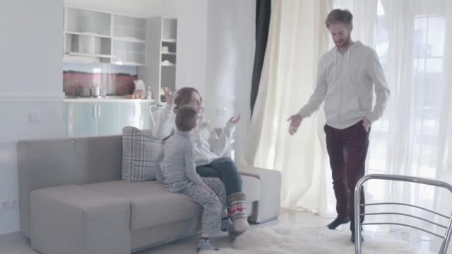 Young parents arguing and disperse to different rooms. Kid is scared and at a loss. Husband angrily looks after the departing wife and swears. Family relationships. Family problems. Slow motion.