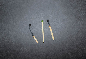 three household matches on a black background.