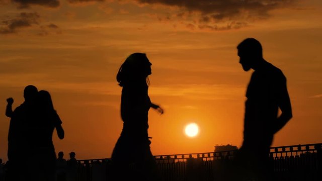 Unrecognizable happy friends silhouette dancing at sunset. Street dance, romantic and urban culture concept