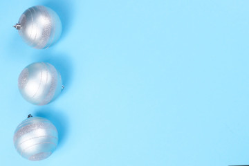 Three Christmas baubles on blue background.