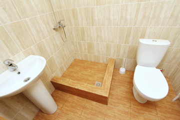 Modern spacious bathroom with bright tiles with toilet and sink. Side view