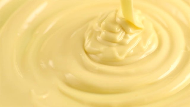 White molten chocolate. Pouring melted liquid premium white chocolate. Confectionery. Slow motion. 3840X2160 4K UHD video footage