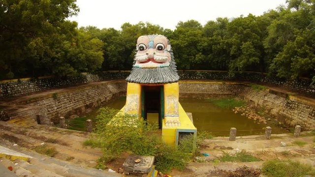 Ancient hand-made pond lion-shaped gate green jungle around