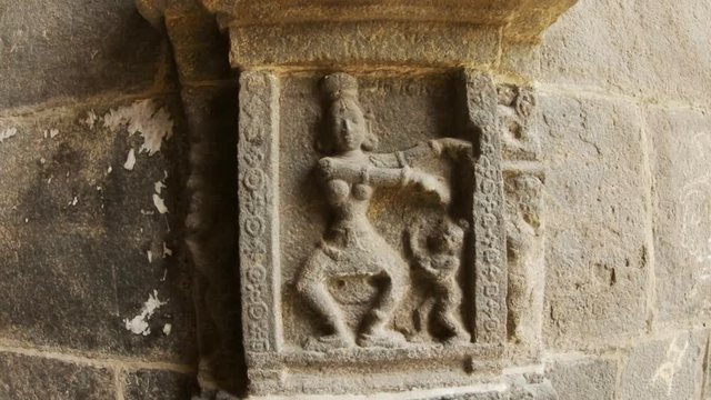 Ancient stone carving Female giant with naked breast and small man dance wall in Tiruvannamalai temple complex