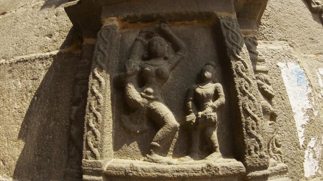 Female dencer giant with naked breast in splits man with drum ancient stone carving preserved in Tiruvannamalai temple