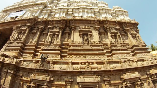 Wall with sculptures and pillars carved in stone of majestic gate tower southern Indian style of architecture