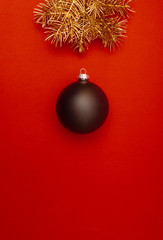 Creative vertical pattern with golden Christmas tree branches and big black bauble. Concept