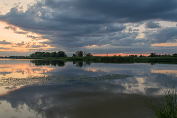 Reflection of clouds in the river at sunset