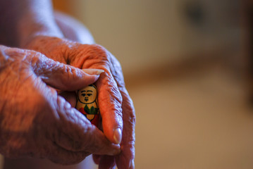 Old Hands Holding a Nesting Doll