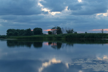 Reflection of clouds in the river at sunset