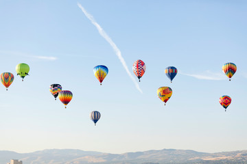 Multi colored hot air balloon flying over blue sky
