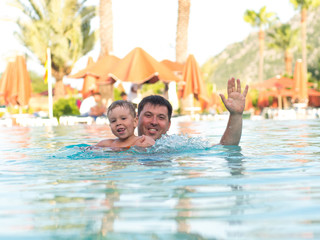 Father and child swimming in the pool