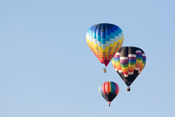 Multi colored hot air balloon flying over blue sky
