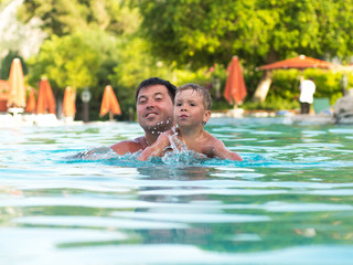 Father and child swimming in the pool