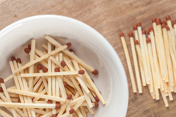 match sticks in the ceramic bowl on the wooden table