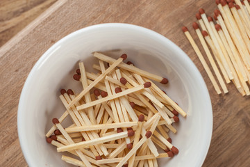 match sticks in the ceramic bowl on the wooden table