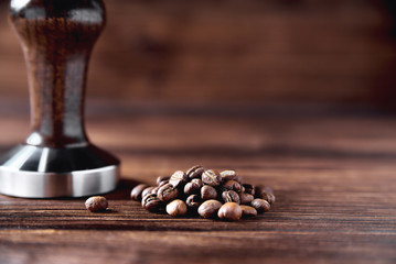 temper coffee beans on a brown wooden background blur
