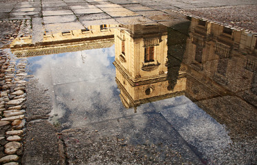 building reflected in puddle