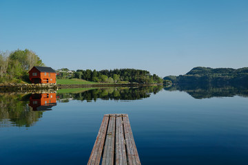 Norway beautiful spring landscape. Mountains reflection in calm water of fjord