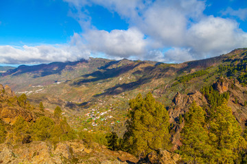 Mountain landscape with green hills and white clouds. Valley with villages Gran Canaria.