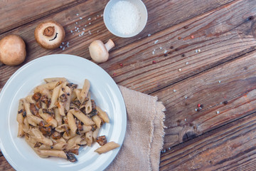 Fototapeta na wymiar Delicious Italian penne pasta with fried creamy mushrooms champignon . Healthy concept.Top view