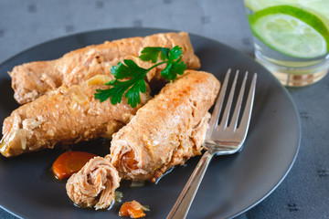 Pork roulades with bacon, carrot, cucumber and onion served on plate.