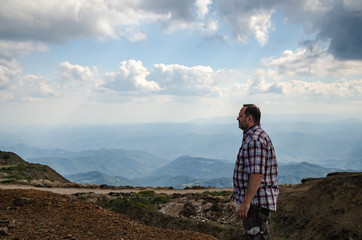 Naklejka premium Man dressed for hiking is walking on top of Kopaonik mountain, Serbia and watching landscape