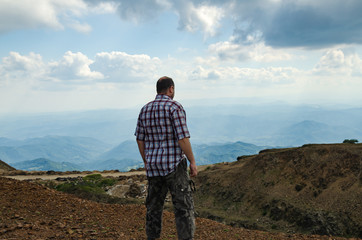 Naklejka premium Man dressed for hiking, is watching landscape from top of Kopaonik mountain, Serbia