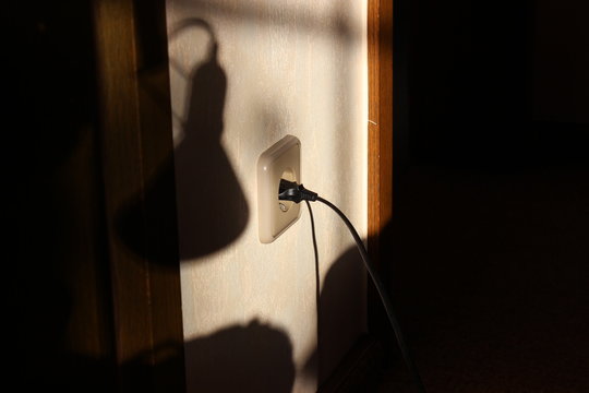 Electricity plug and lamp shadow