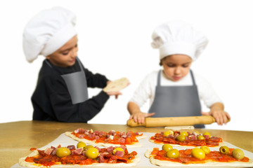 funny happy caucasian girl and boy  preparing pizzas to baking in kitchen	