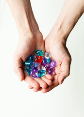 Some small colorful plastic hearts in a hand on daylight. Symbol of love and care.