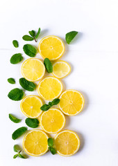 White background with lemon, orange slices and mint. Concept with fresh fruit. Lemon, Orange, Mint. View from above.