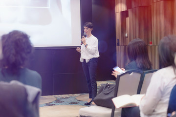 Beautiful business woman with microphone in her hand speaking at the  conference or seminar.;