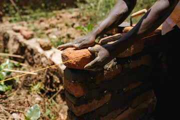 man in Uganda buidling a house