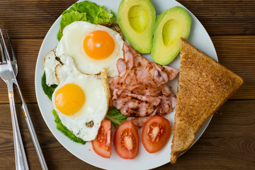 Healthy breakfast. Avocado, eggs sandwich with whole grain bread on wooden background. Copy space