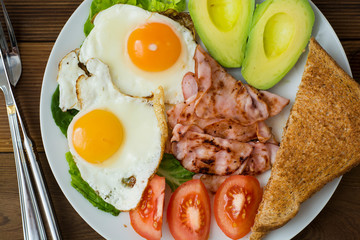 Healthy breakfast. Avocado, eggs sandwich with whole grain bread on wooden background. Copy space