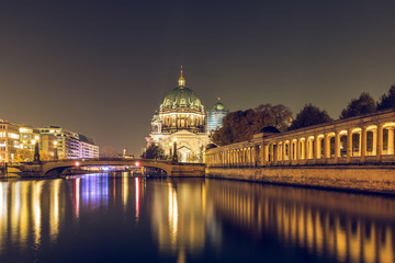 Berlin Cathedral at night with the Friedrichs Bridge. On the river Spree reflect the lights. The illuminated pillar gallery on the Spree shore